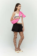 Pink croissant-shaped mini bag with shirt texture and adjustable sleeve handles for shoulder or crossbody wear
