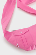 Pink croissant-shaped mini bag with shirt texture and adjustable sleeve handles for shoulder or crossbody wear