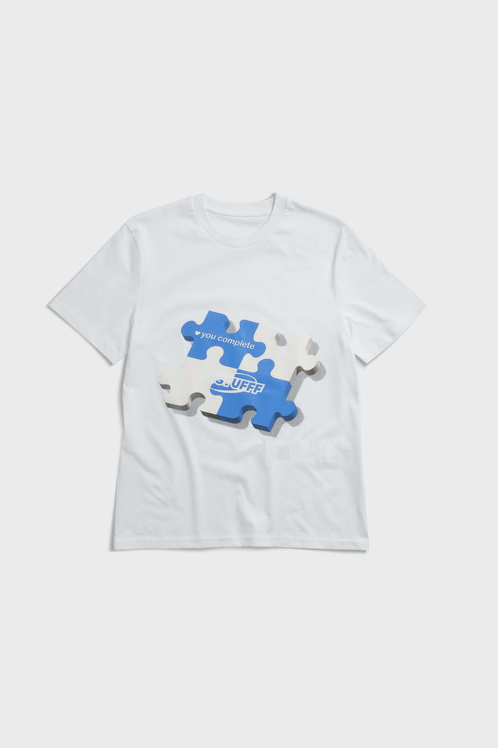 White t-shirt with blue puzzle graphic and hidden UV reactive puzzle pieces print that turns pink in sunlight