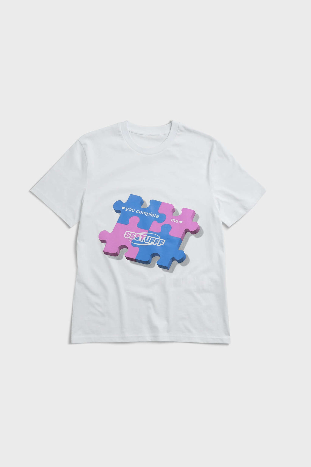 White t-shirt with blue puzzle graphic and hidden UV reactive puzzle pieces print that turns pink in sunlight