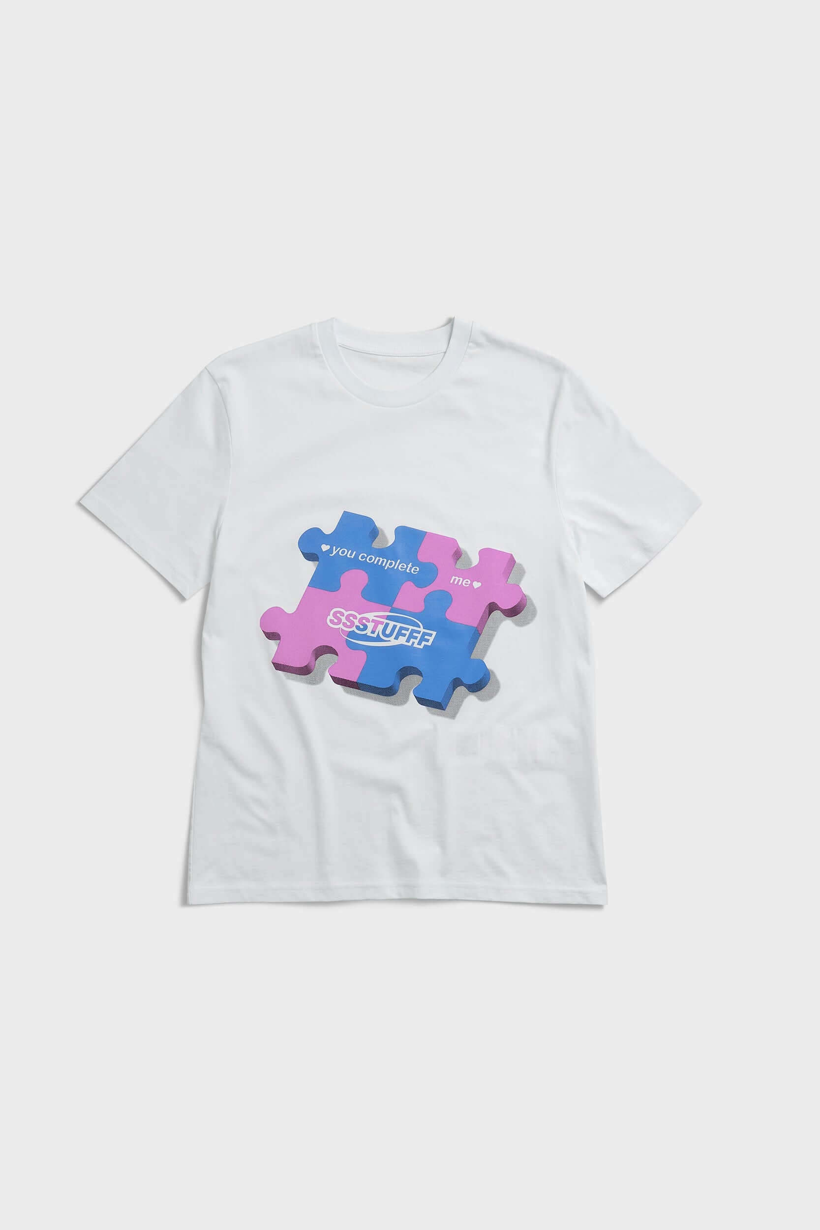 White t-shirt with blue puzzle graphic and hidden UV reactive puzzle pieces print that turns pink in sunlight
