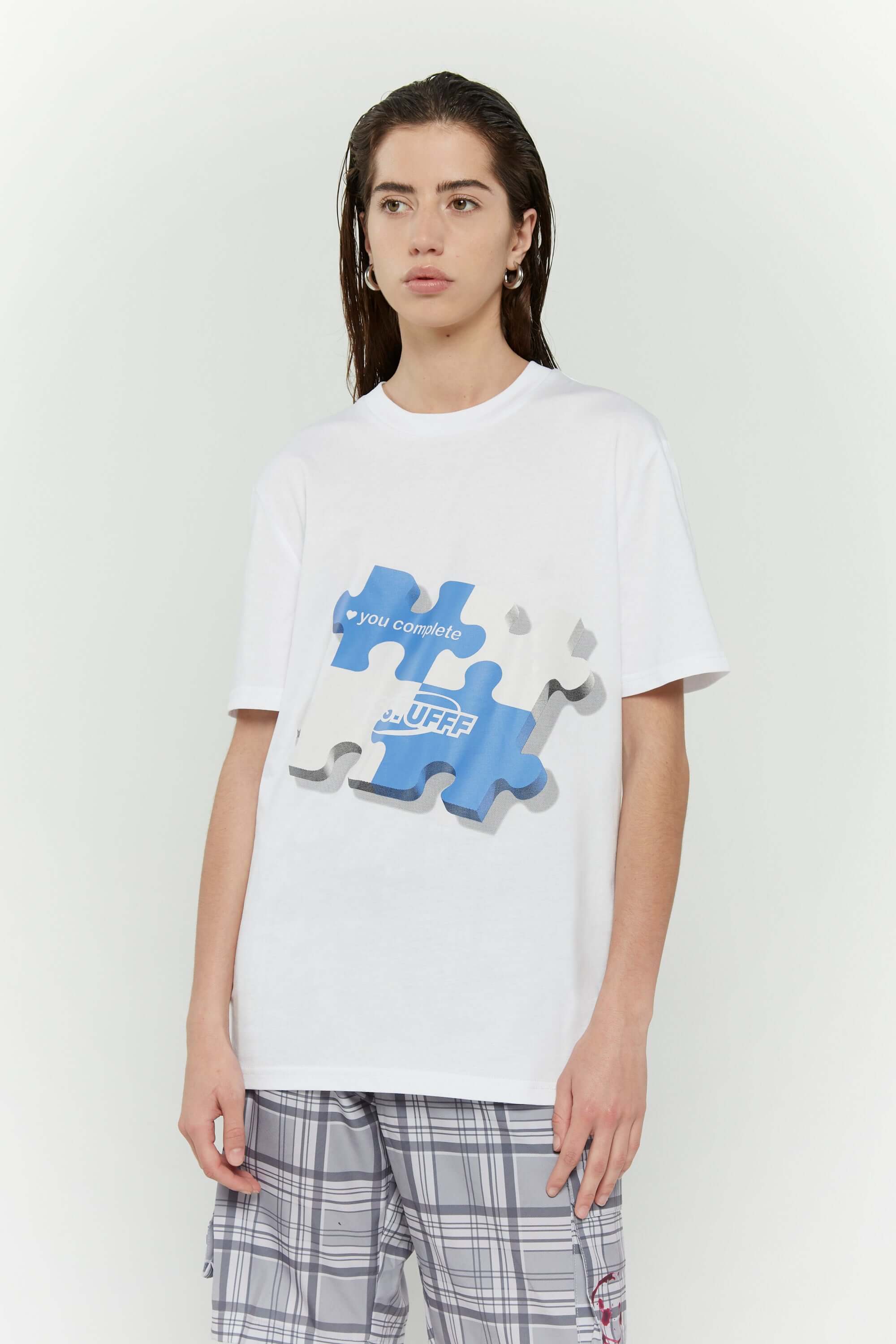 White t-shirt with blue puzzle graphic and hidden UV reactive puzzle pieces print that turns pink in sunlight