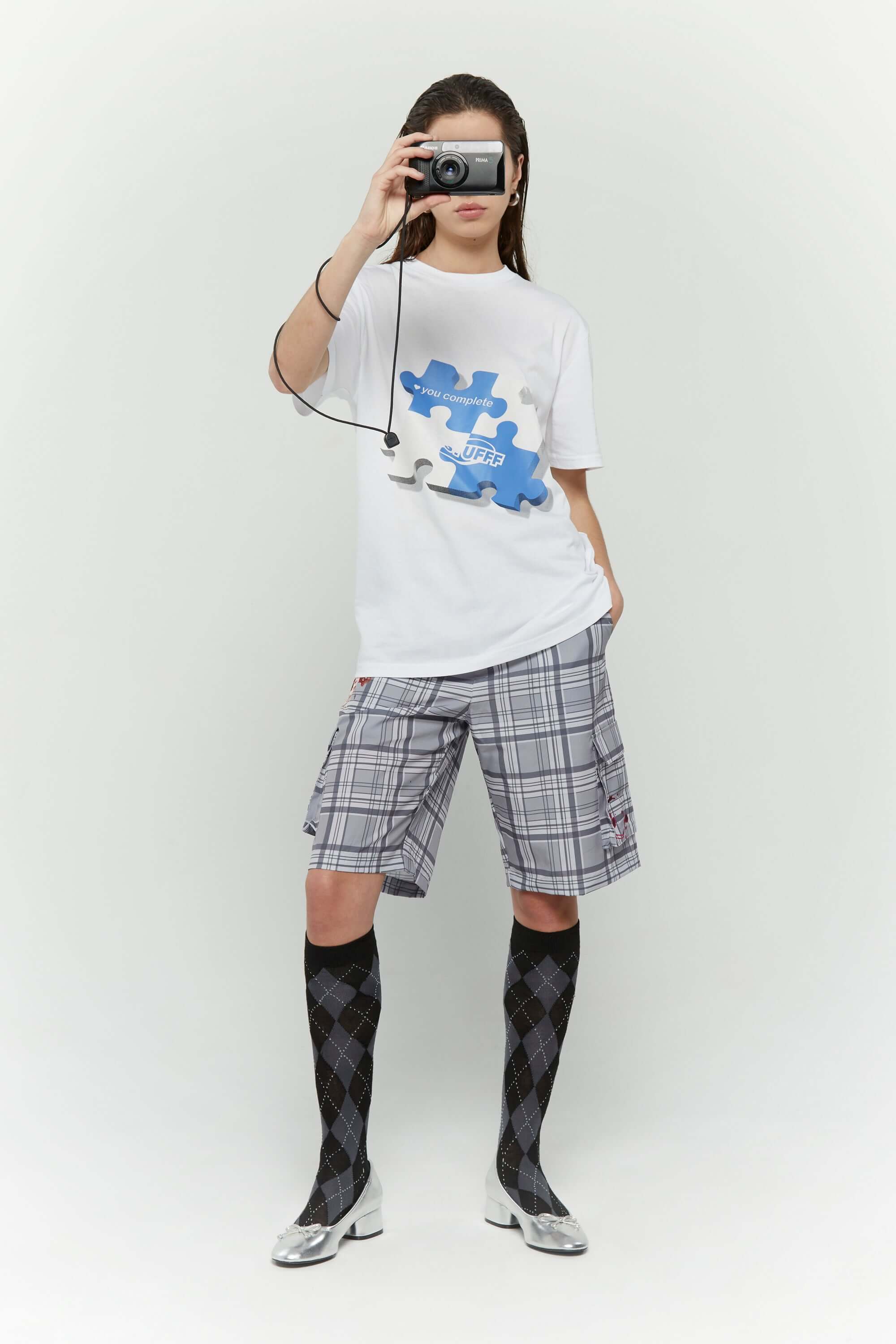 White t-shirt with blue puzzle graphic and hidden UV reactive puzzle pieces print that turns pink in sunlight