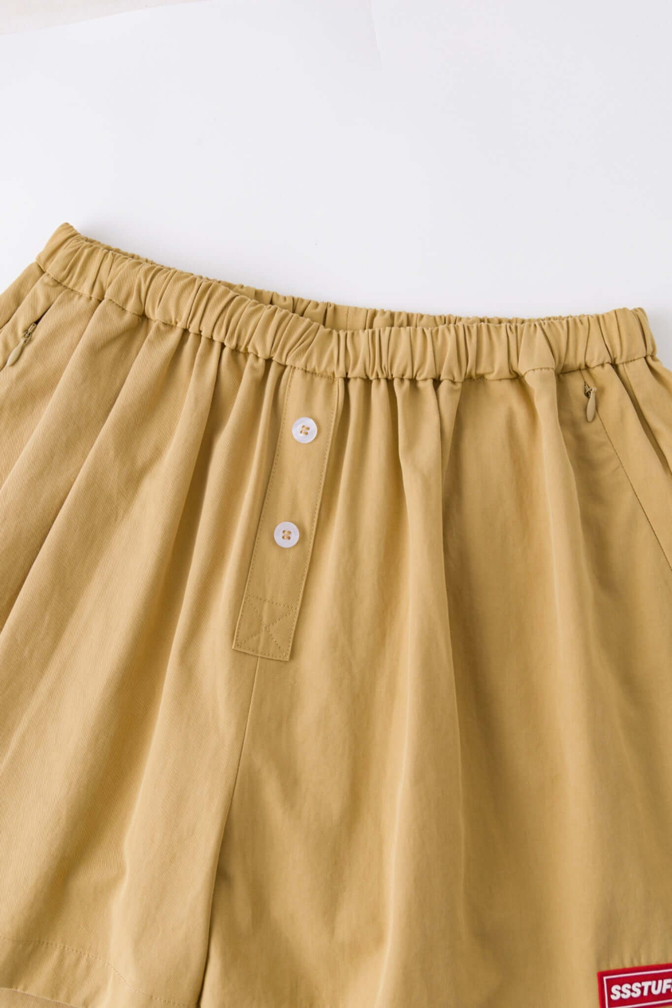 Beige boxer shorts with a red embroidery logo 
