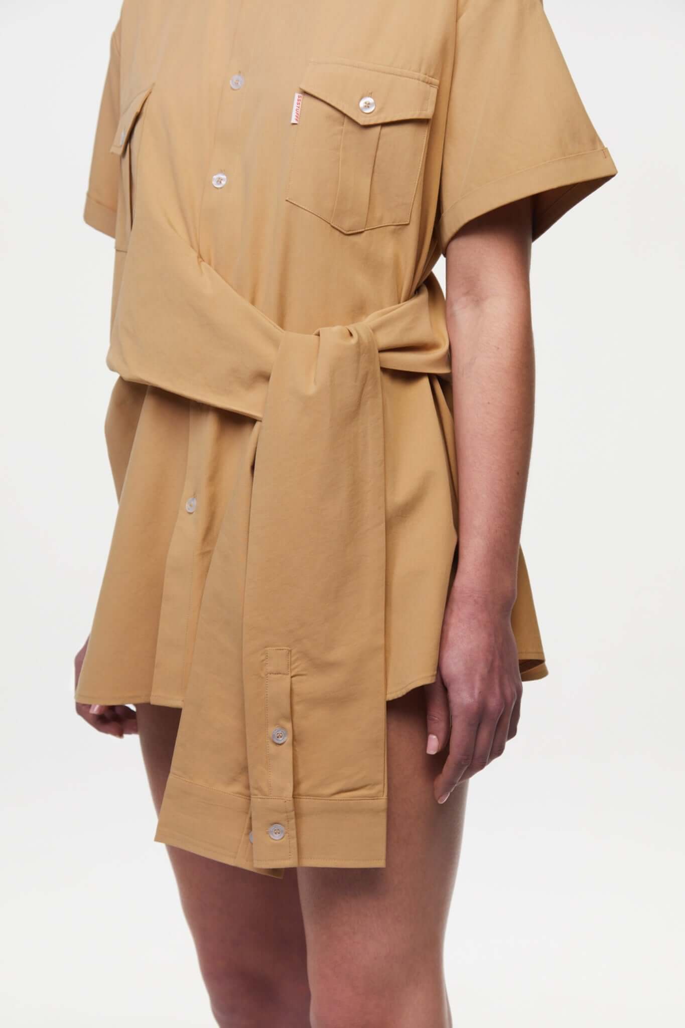 Beige shirt with 4 sleeves making a tie waist 
