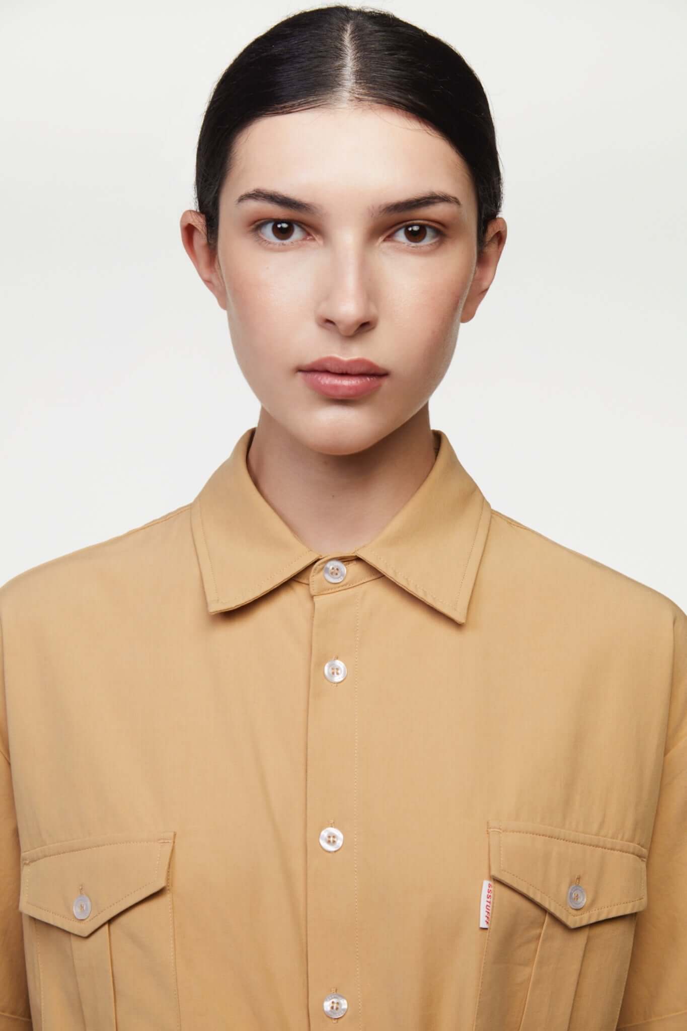 Beige shirt with 4 sleeves making a tie waist 
