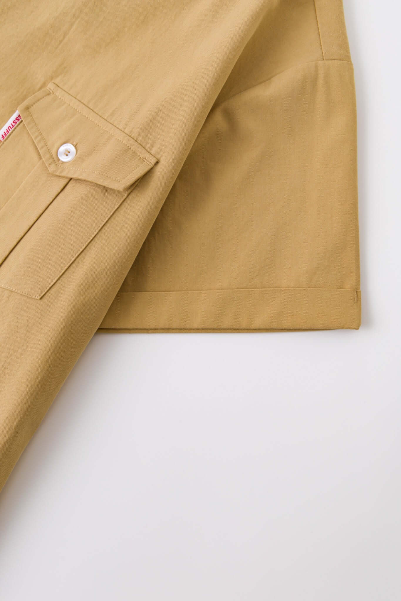 Beige shirt with 4 sleeves making a tie waist 
