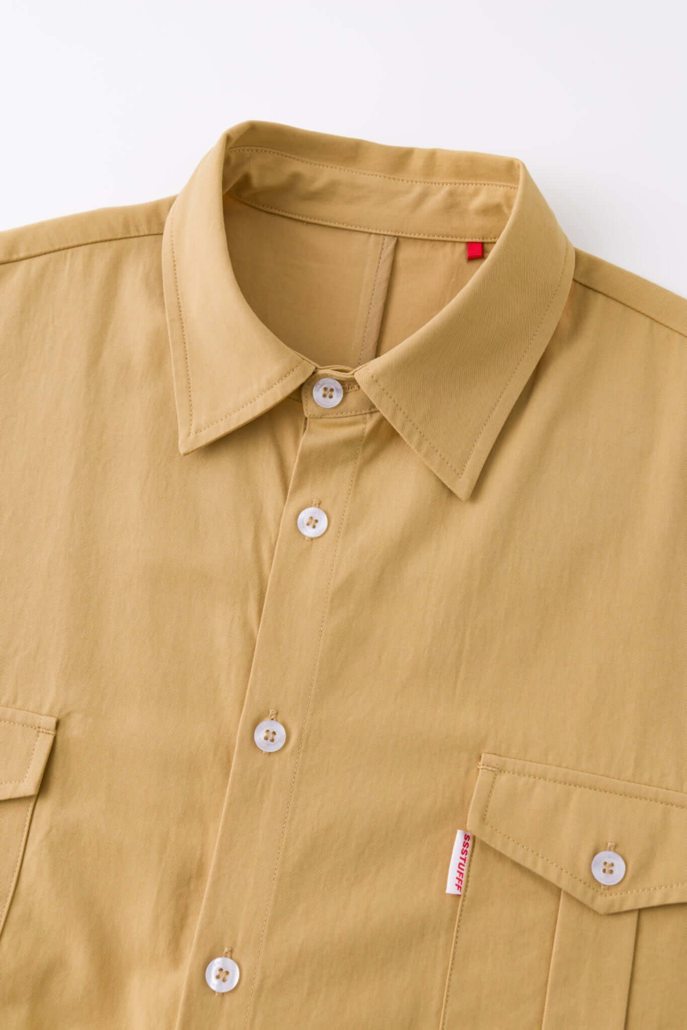 Beige shirt with 4 sleeves making a tie waist 
