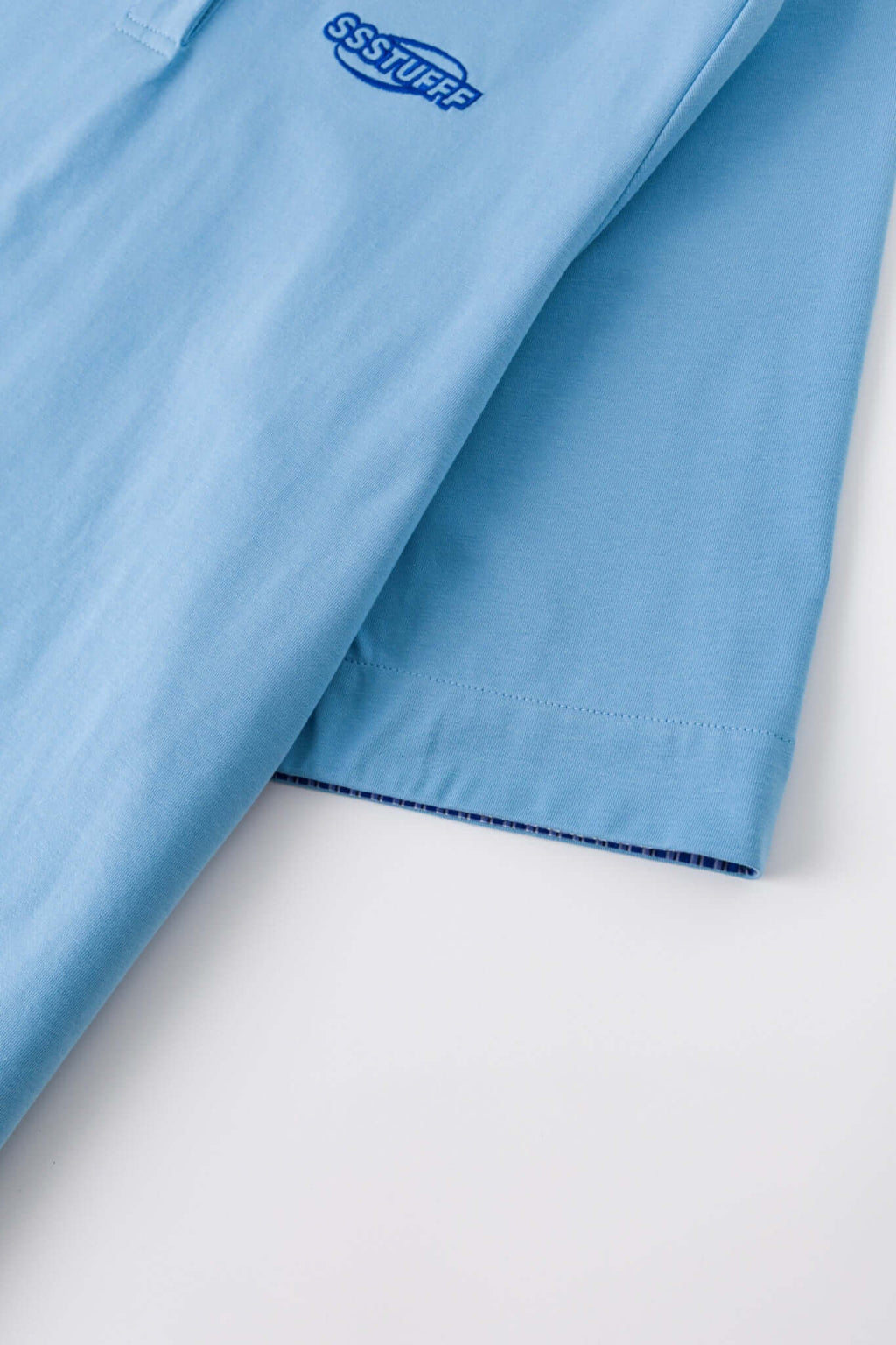 Blue polo shirt with checkered collar and sleeves
