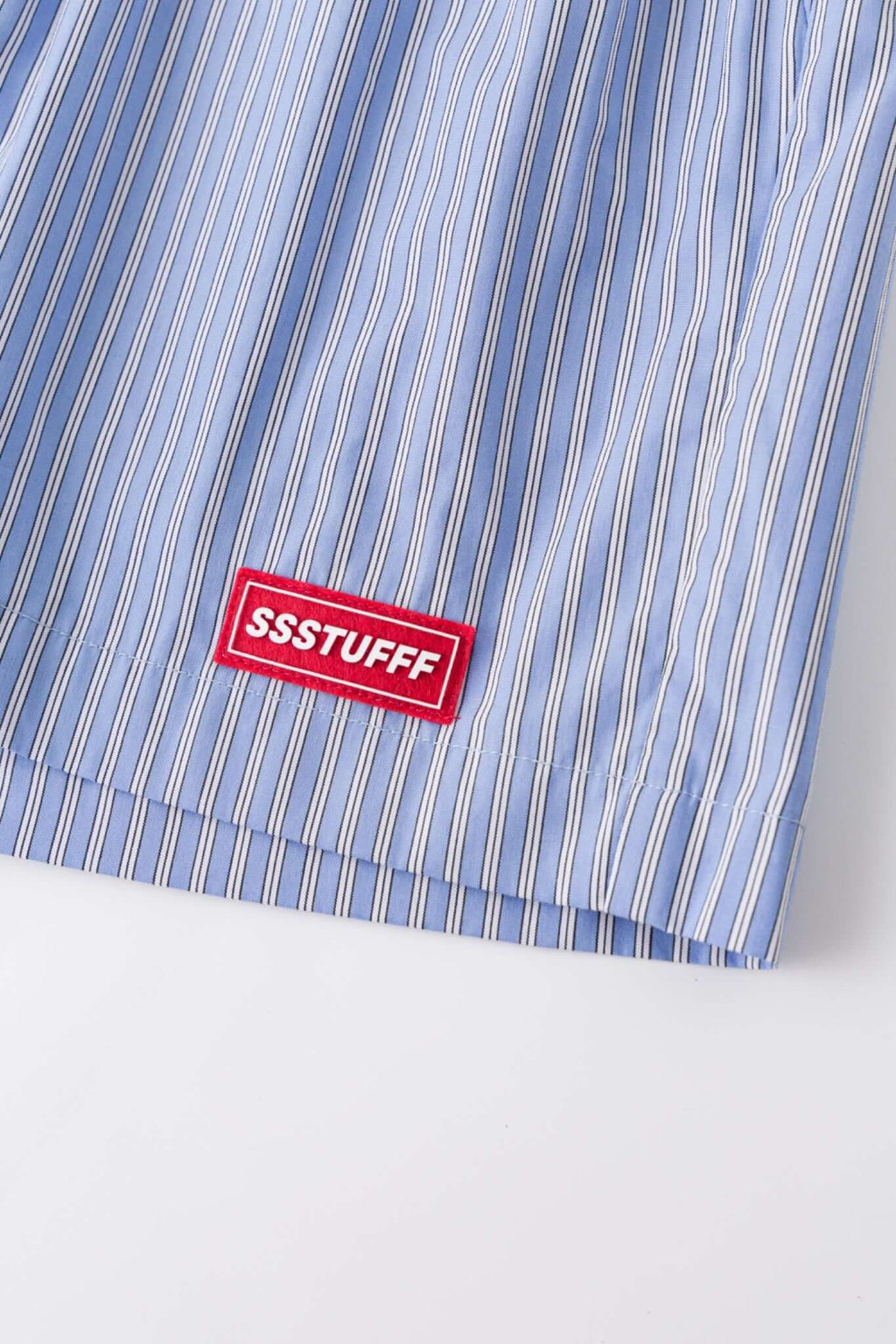 Blue striped boxer shorts with a red embroidery logo 

