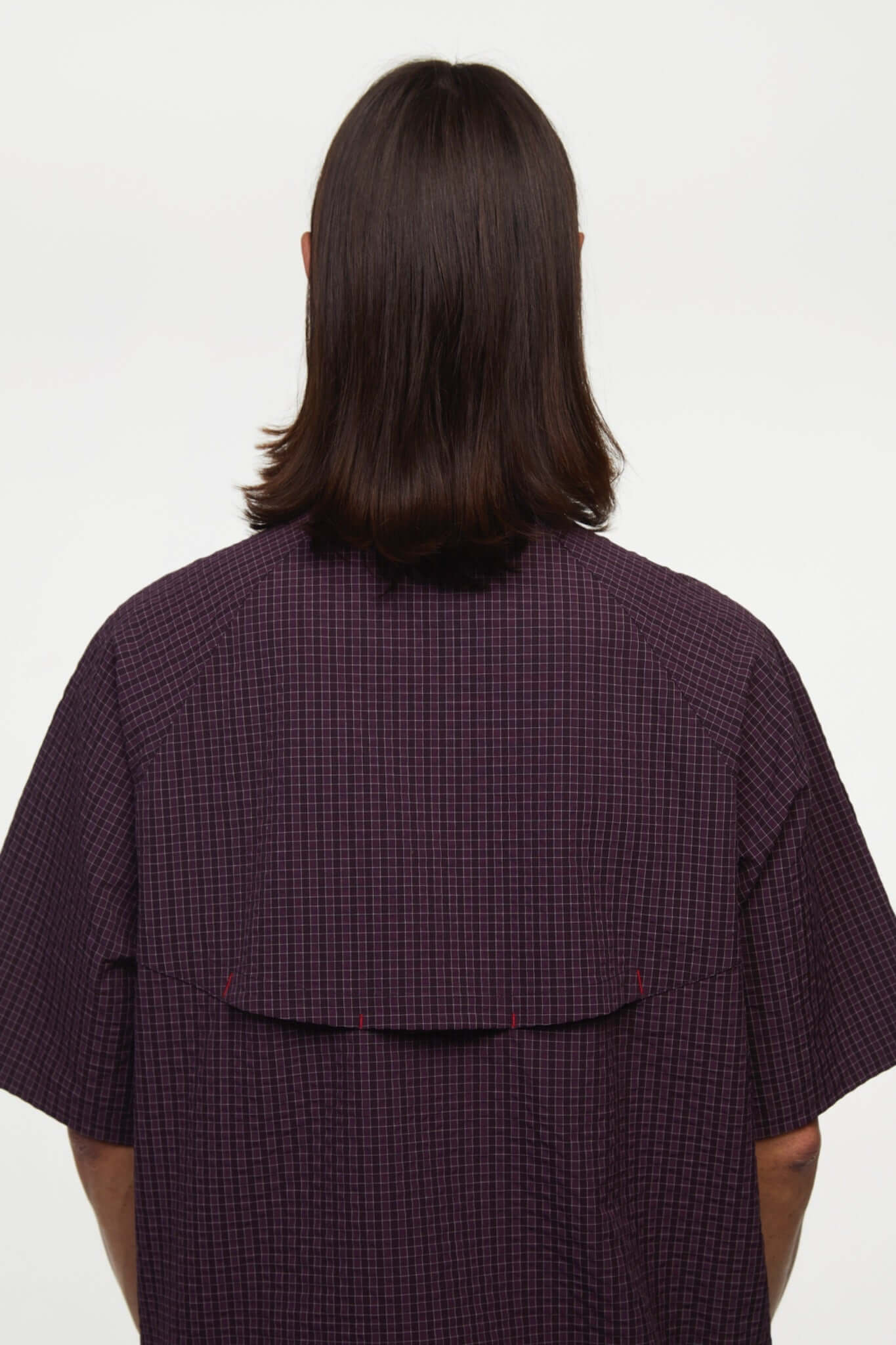 Burgundy checkered shirt with a red logo and red details in the zipper
