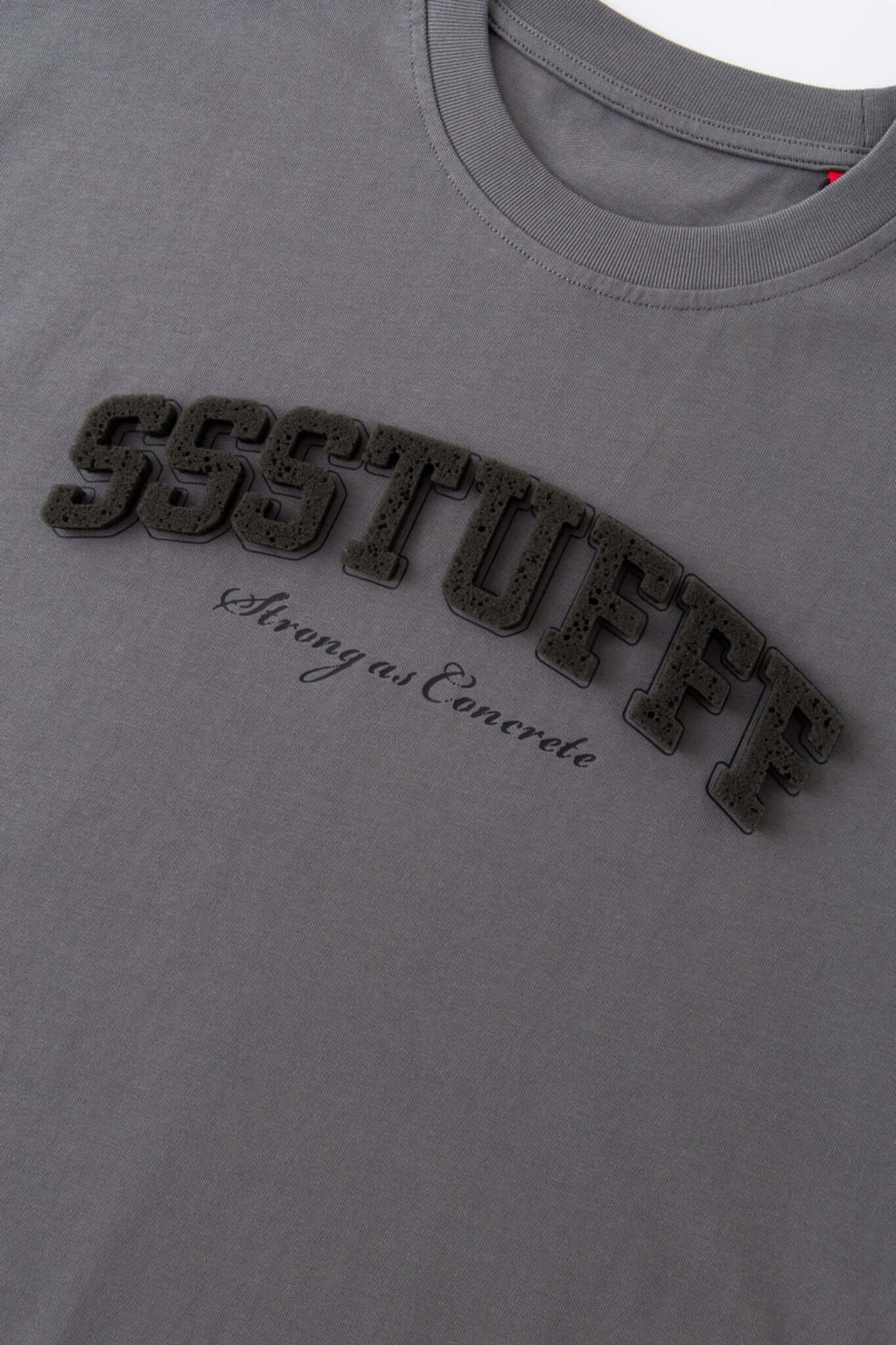Gray t-shirt with sponge texture text with the brand name
