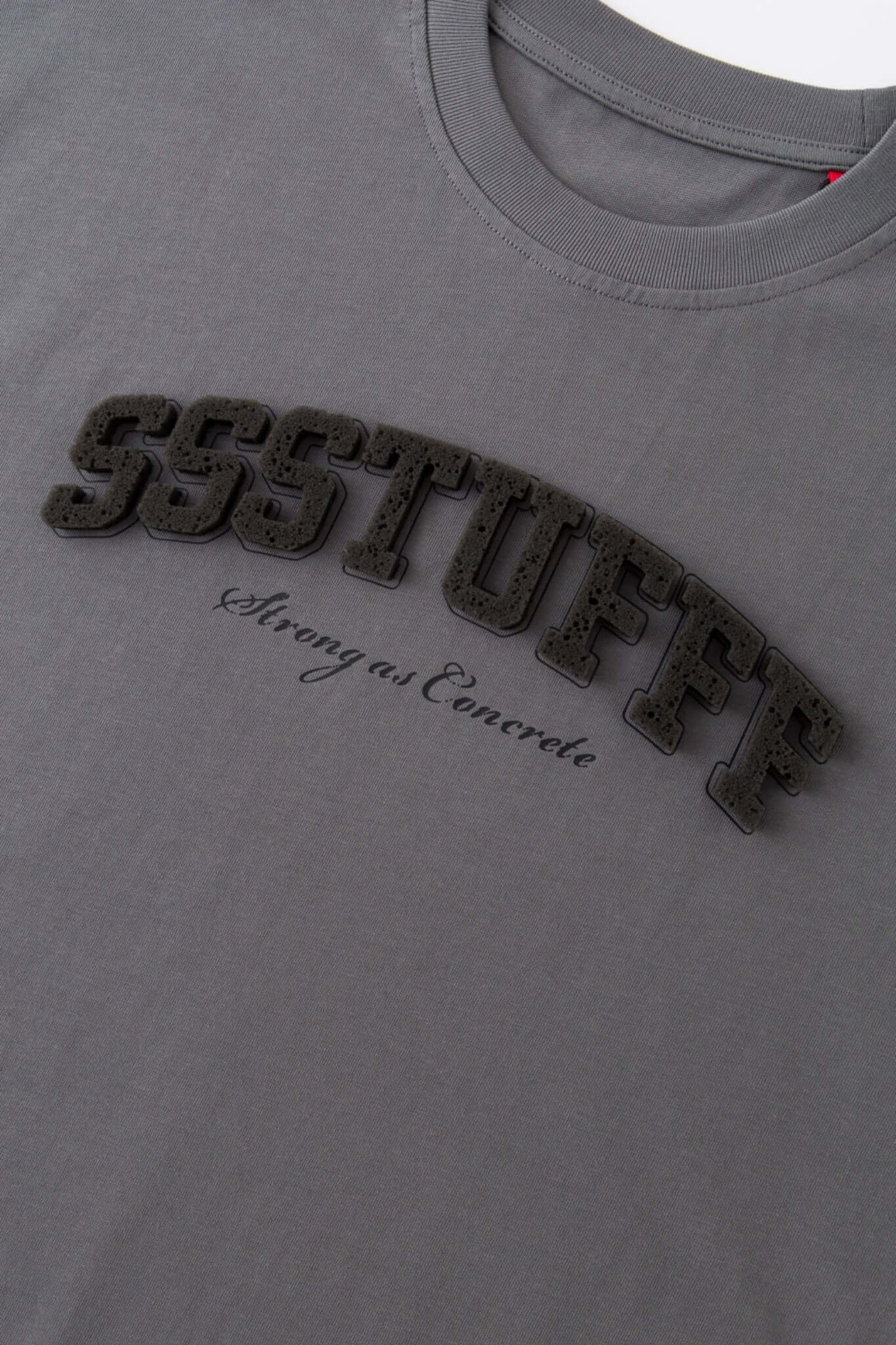Gray t-shirt with sponge texture text with the brand name

