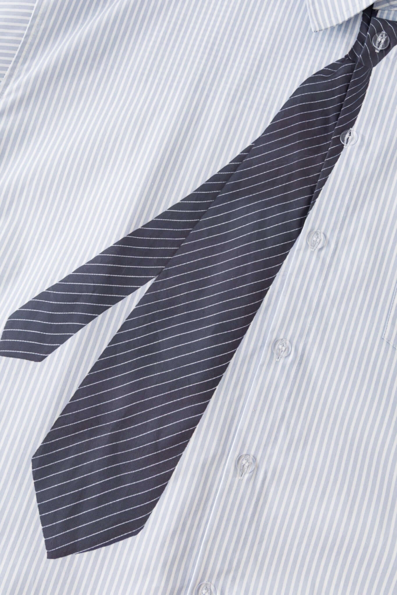 Light blue stripes shirt with a black tie graphic 
