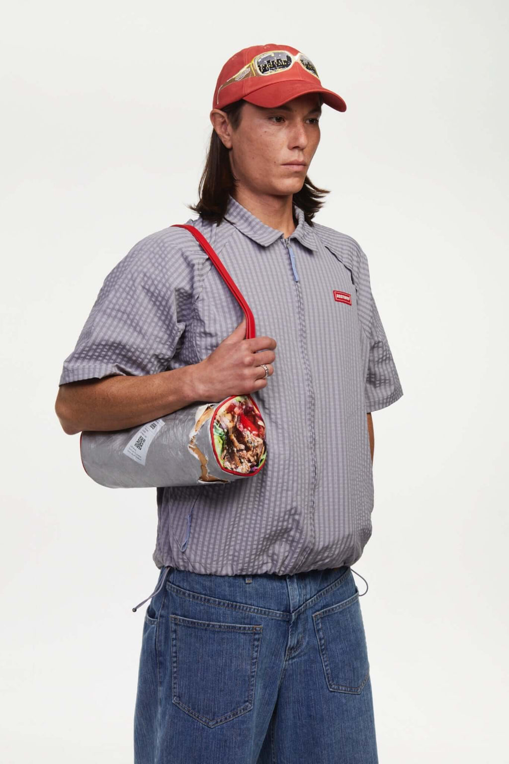 Grey checkered shirt with a red logo and red details in the zipper
