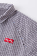 Grey checkered shirt with a red logo and red details in the zipper
