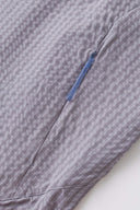 Grey checkered shirt with a red logo and red details in the zipper
