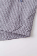 Grey checkered shirt with a red logo and red details in the zipper
