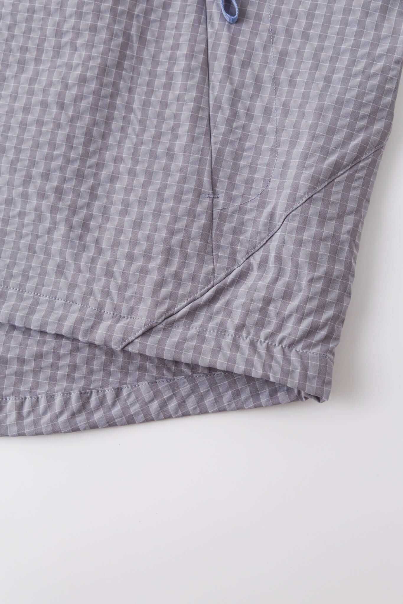 Grey checkered shirt with a red logo and red details in the zipper

