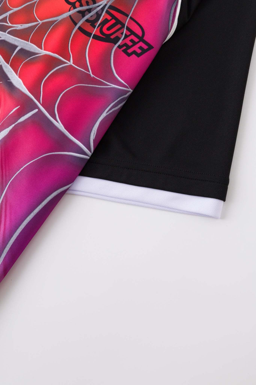Black jersey shirt with a colorful spider web design with the word SSSTUFFF on it
