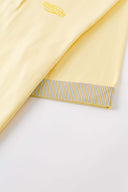 Yellow polo shirt with checkered collar and sleeves
