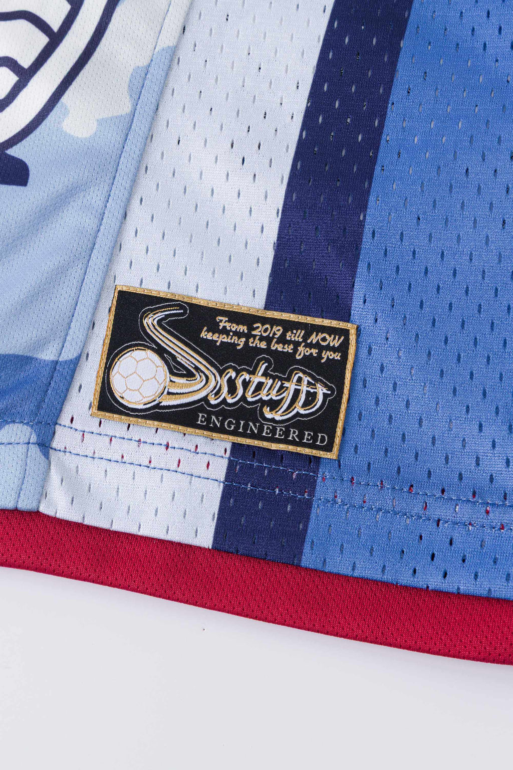 Close-up of a blue sports jersey with a 'SSSTUFFF' brand label on a white background