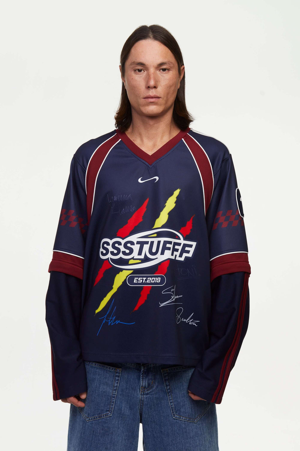 Person wearing a navy blue sports jersey signed, with red and yellow accents, with the 'SSSTUFFF' logo in white on a white background