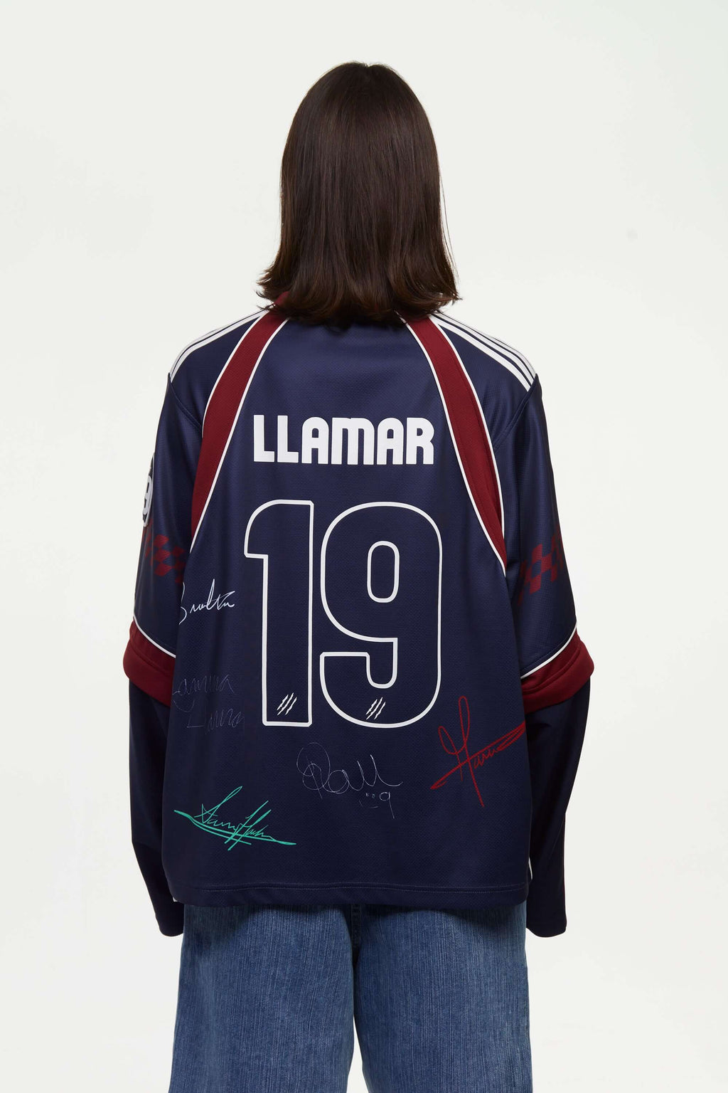 Person wearing a navy blue sports jersey signed with 'LLAMAR' and number '19' on the back, against a white background.