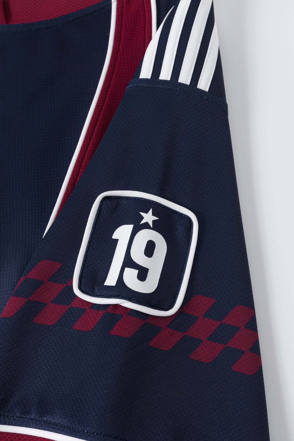 Navy sports jersey with number 19 and checkered pattern on a white background
