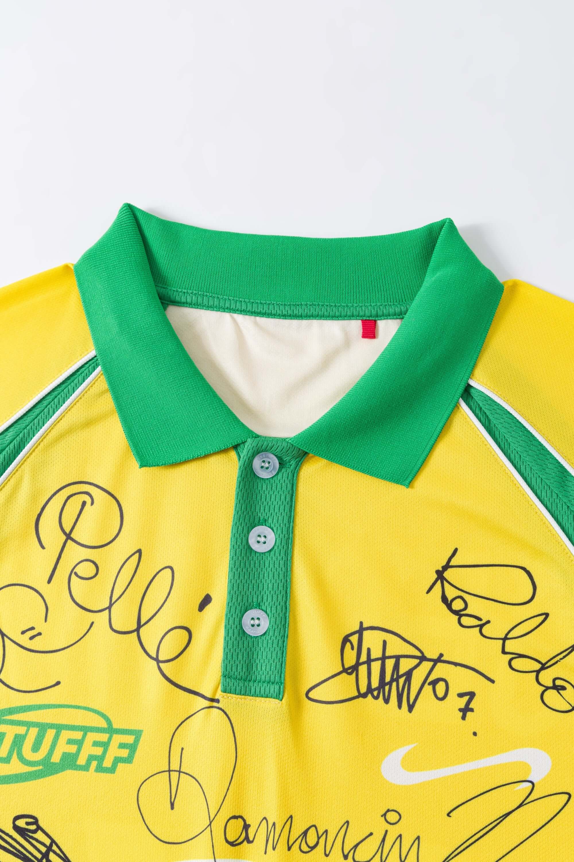 Yellow polo shirt with green collar and text on a white background