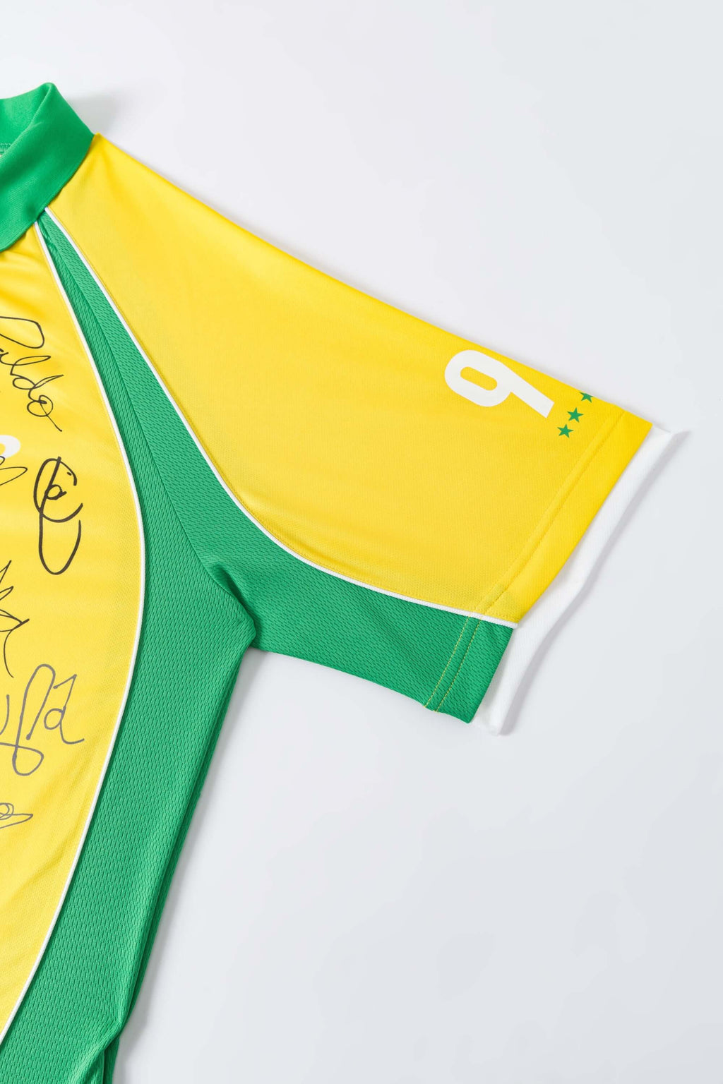 Yellow and green sports jersey with signatures on a white background