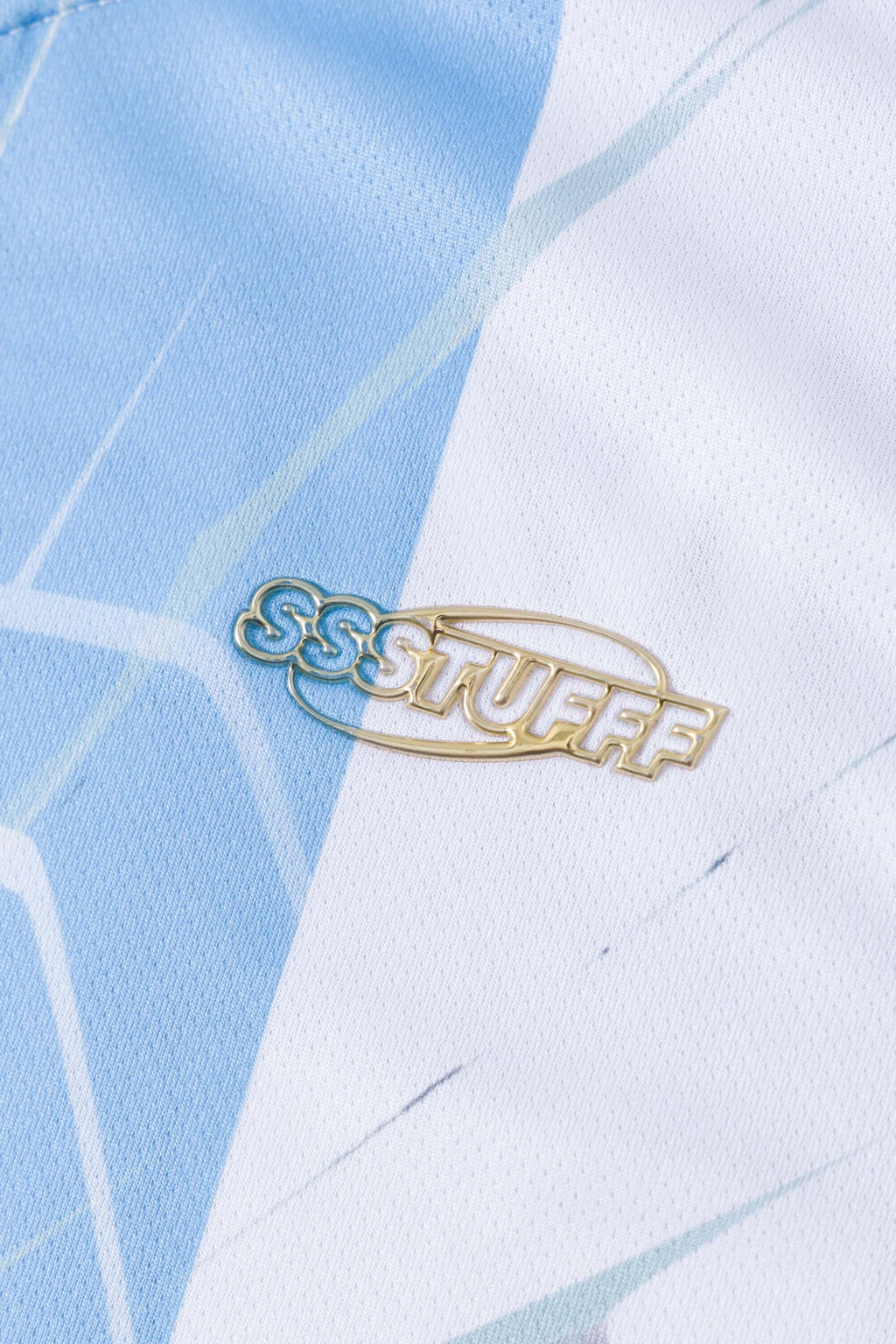 Close-up of a light blue and white polo with 'SSSTUFF' logo 