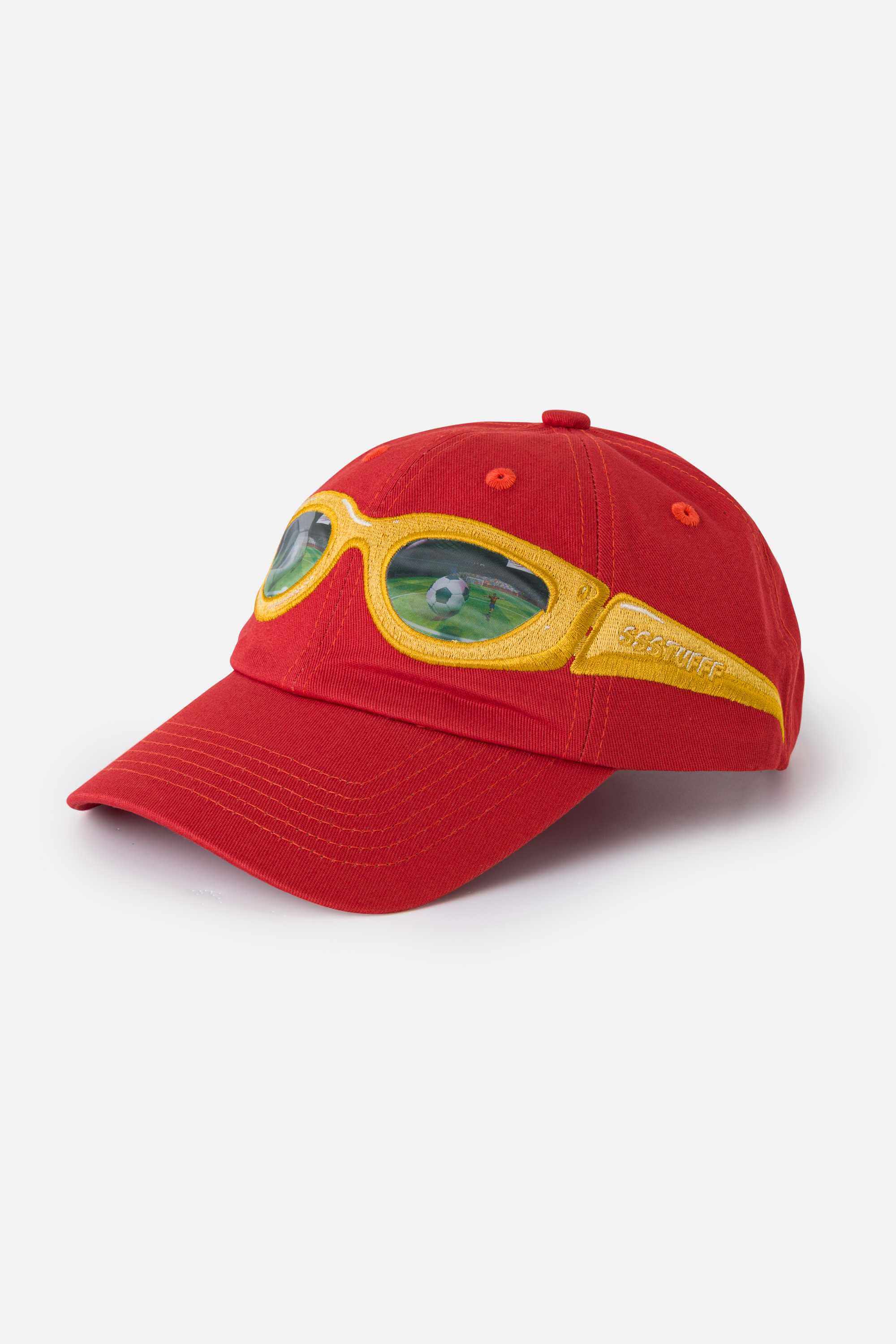Red cap with yellow sunglasses design on a white background. The lens of the glasses has a lenticular effect with a football ball inside a goal