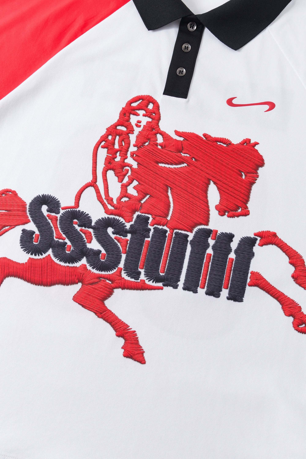 Close-up of a red and white polo shirt with a horse and text design printed, mimicking embroidery
