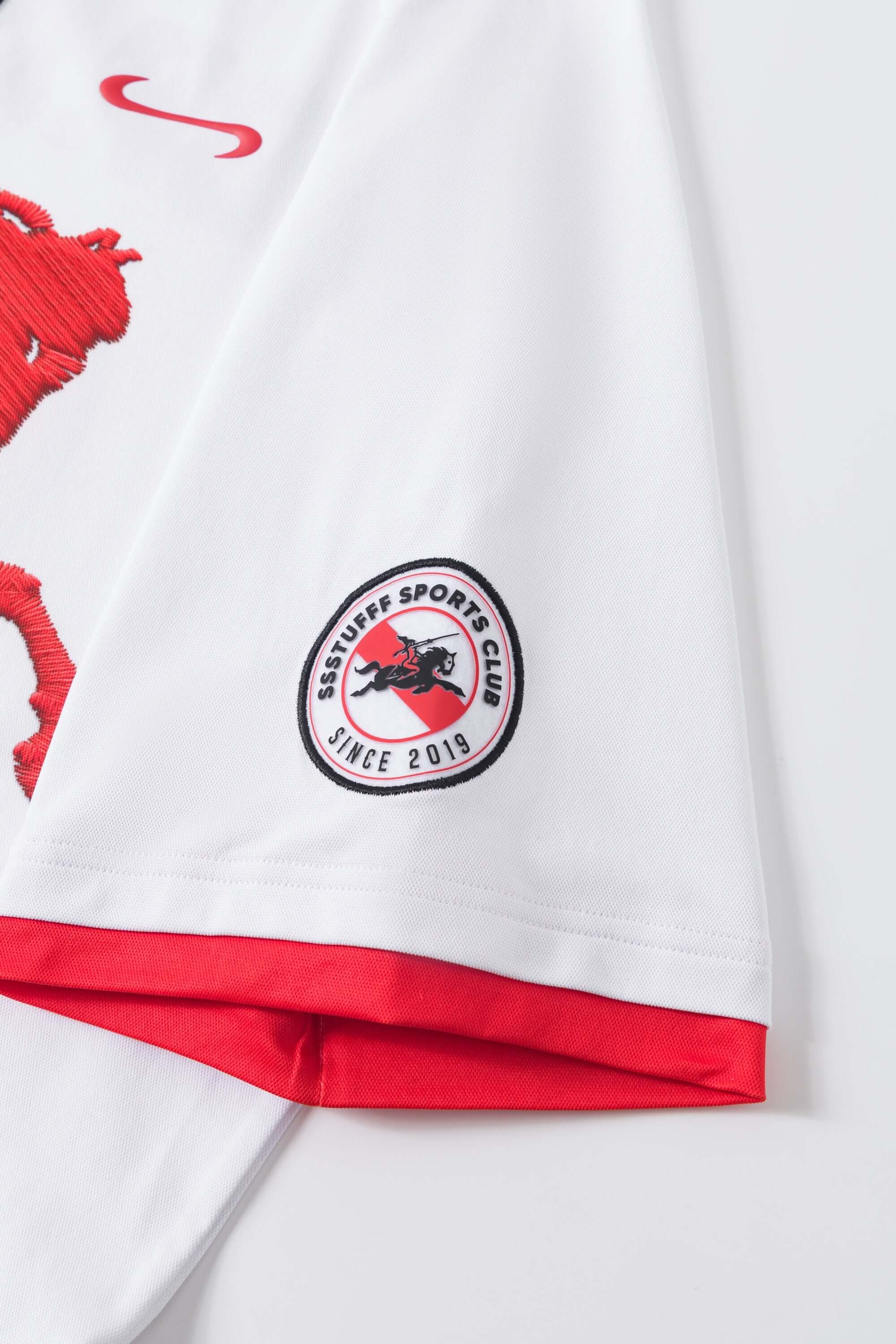 White sports jersey with red accents and a logo on a white background