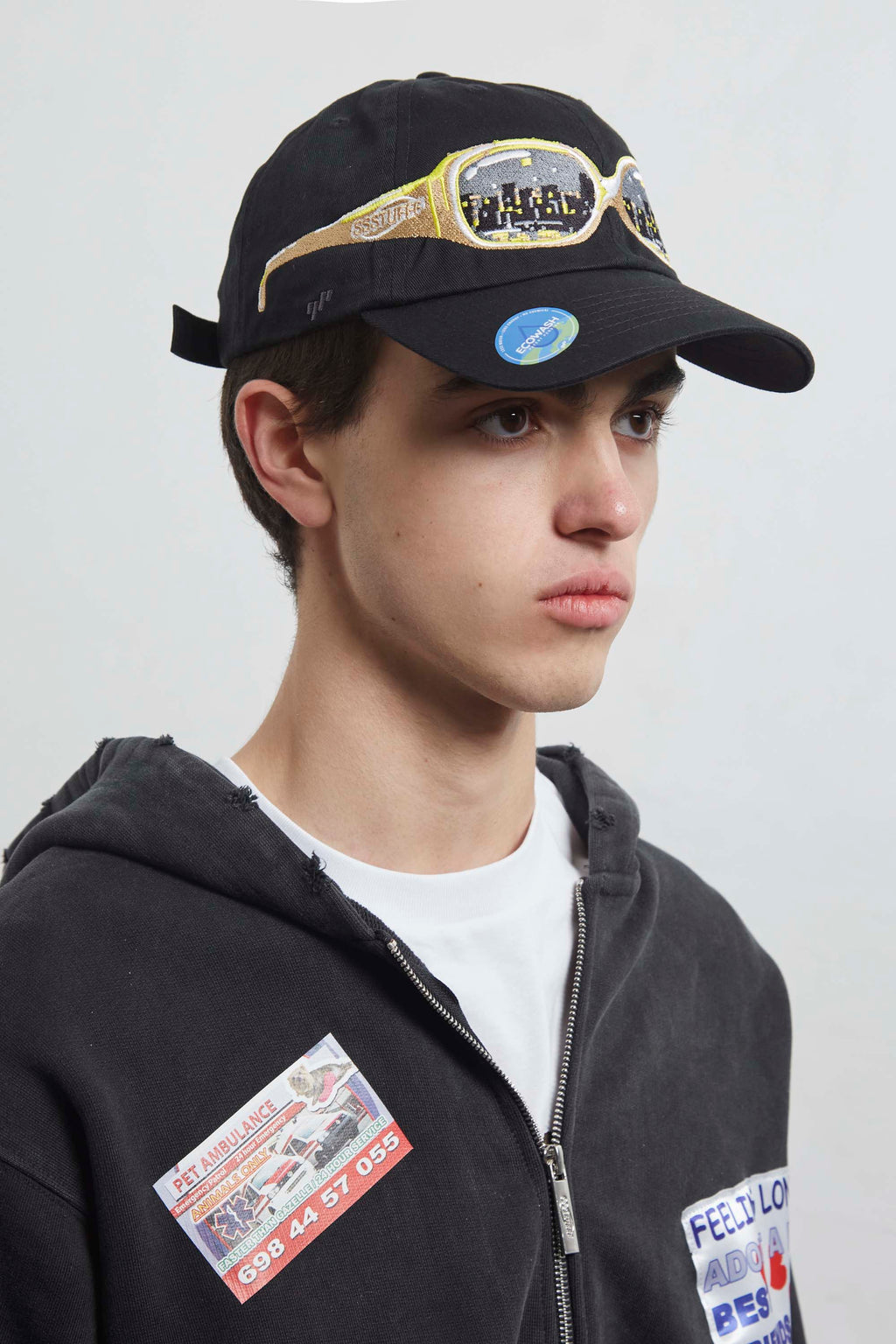 Black cap with embroidery sunglasses design on a light gray background