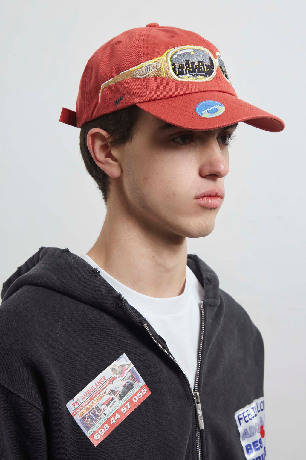 Red cap with a embroidery glasses on it, seeing a city on them.