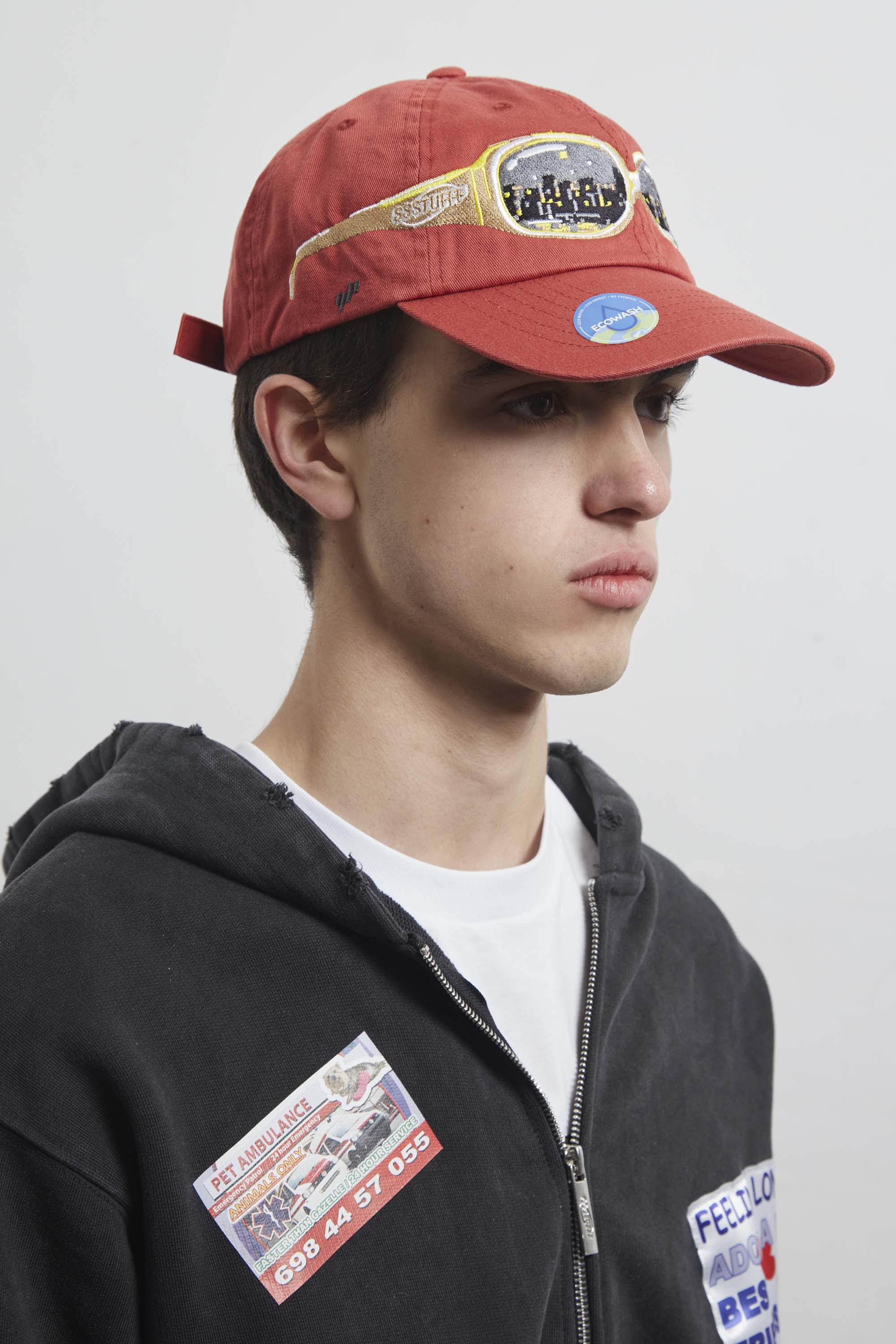 Red cap with a embroidery glasses on it, seeing a city on them.