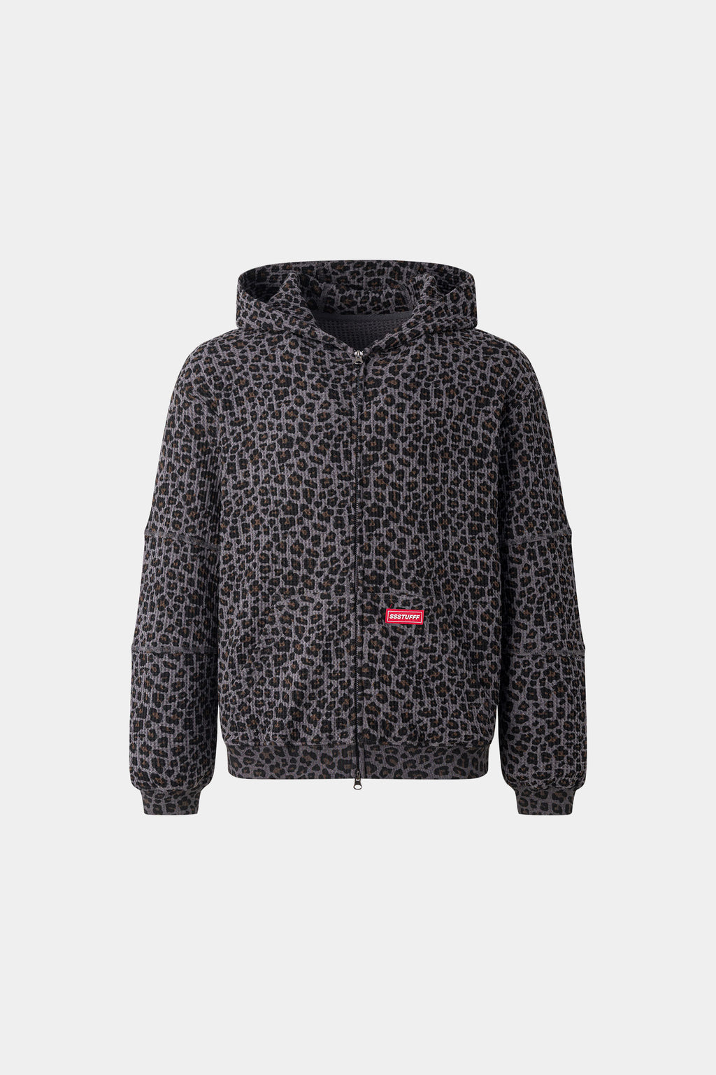 Leopard print zip up with a red label on a light gray background