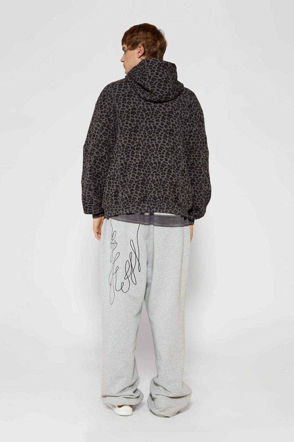 Leopard print zip up with a red label on a light gray background