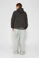 Leopard print zip up with a red label on a light gray background