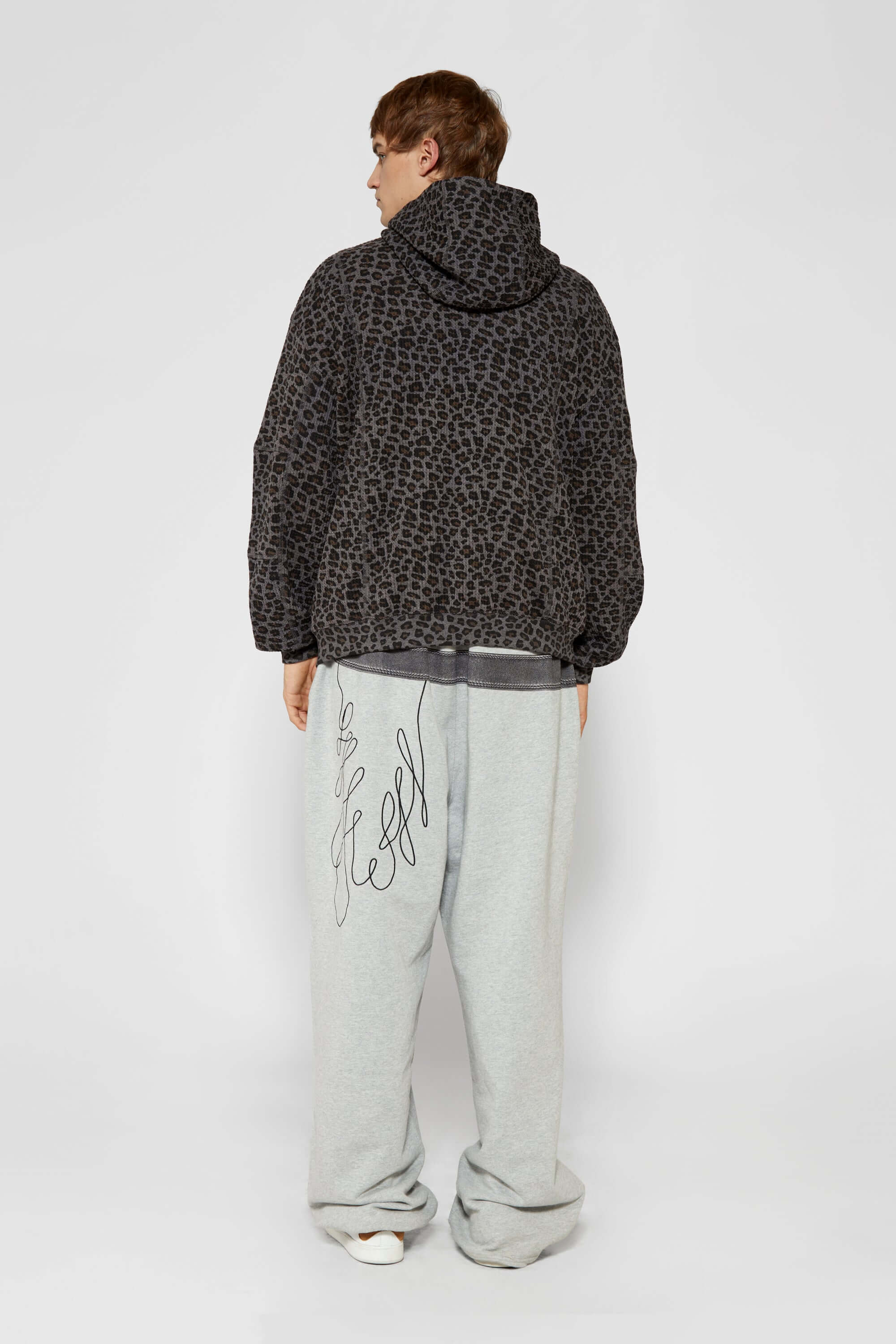 Leopard print zip up with a red label on a light gray background