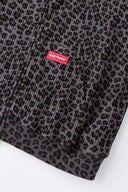 Leopard print zip up with a red label on a light gray background