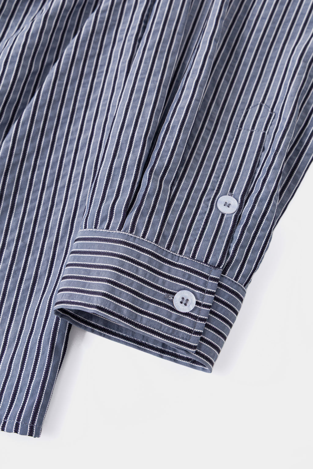 Detail of the buttoned cuff on the striped shirting.