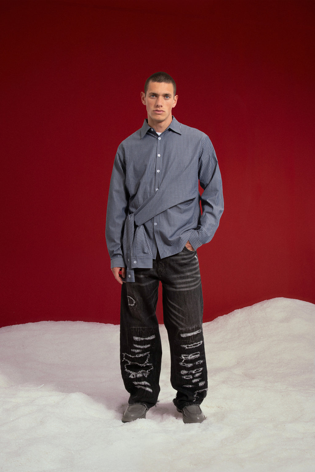 4 Sleeves Button Up Shirt in navy stripe, with two extra sleeves knotted at the waist. Worn on a model, full-length front view.