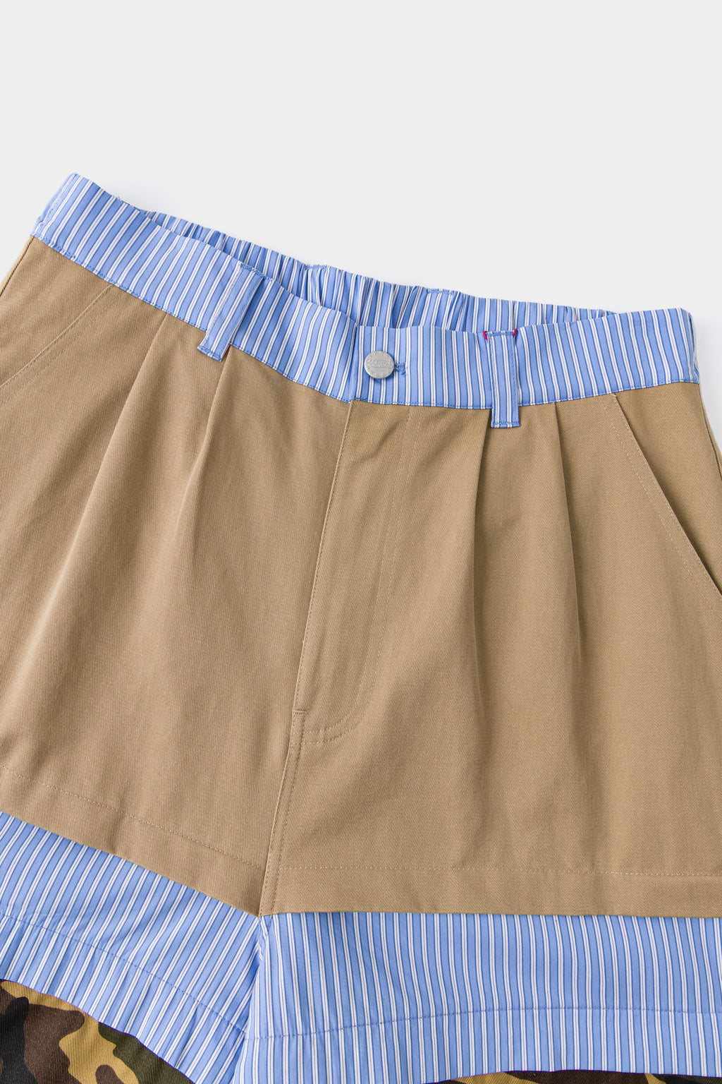 Close-up of the khaki waistband over the blue striped shirting layer.