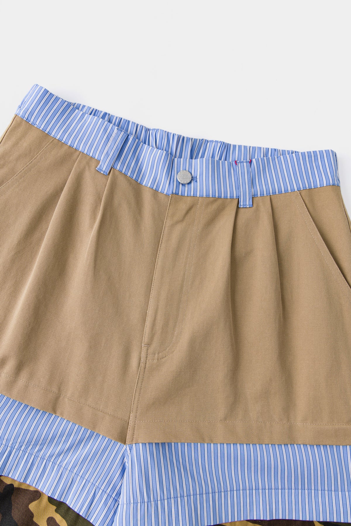 Close-up of the khaki waistband over the blue striped shirting layer.