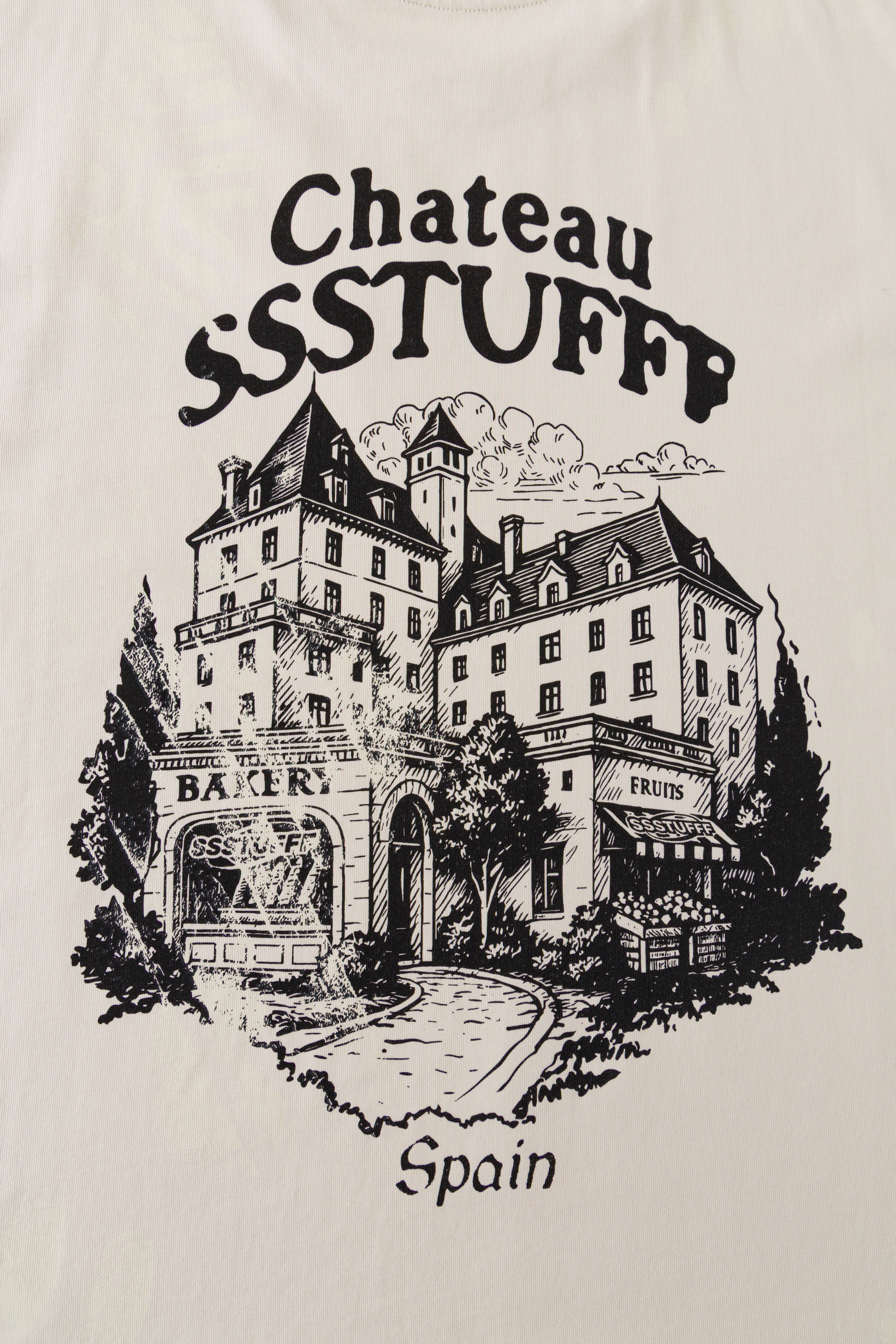 Close-up of the back print: the chateau, the Bakery and Fruits shopfronts and Spain lettering.