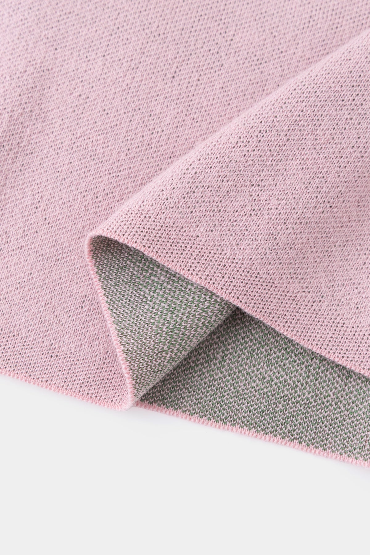 Close-up of the hem folded back, showing the grey reverse side of the pink knit.