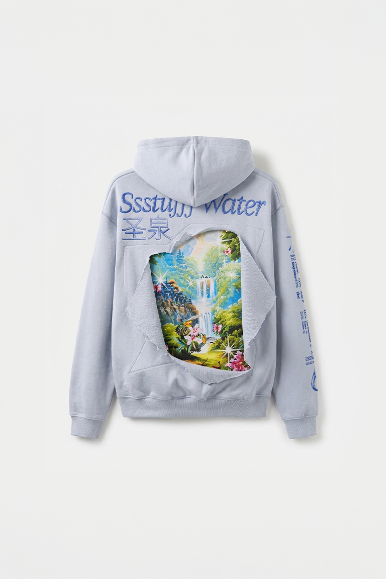 A light gray hoodie shown from the back, featuring a large colorful forest waterfall graphic with a tiger and a torn-paper effect, blue text reading 'Ssstuuu Water' and Chinese characters, and blue text printed down the sleeves.